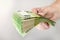 Large stack of euros in hand. Banknotes of 100 euros in a male hand on a uniform background. A man holds out his hand