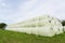 Large stack of hay bales wrapped in plastic. UK