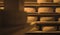 Large stacks of cheese wheels inside a wooden storehouse to age cheese. Rolls of cheese on wooden shelves in a vintage cold