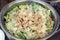 A large stainless bowl of Caesar salad on a catering table served for an event