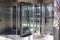 A large stainless steal and glass revolving door in front of an office building in downtown Atlanta