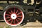 Large steel wheels of old steam locomotive red with white outline