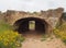 Large stone arch carved into rock with an entrance door at the tomb of the kings in paphos cyprus