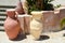 large stone, clay old ancient vintage burnt carved heavy jugs, vases with patterns on the stone floor against the backdrop of a s