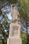 Large stone statue of Elijah - the Prophet stands on a stone pedestal in the garden of the Deir Al-Mukhraqa Carmelite Monastery in