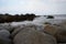 Large stones on the seashore, stone wild beach, seascape in cloudy weather.