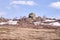 Large stones. White snow. Dry trees