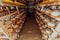 A large storehouse of manufactured cheese standing on the shelves ready to be transported to markets