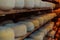 A large storehouse of manufactured cheese standing on the shelves ready to be transported to markets