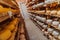 A large storehouse of manufactured cheese standing on the shelves ready to be transported to markets