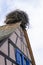 Large stork nest on the roof gable of a traditional wooden half-timbered house in the Alsace region of France