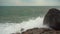 Large storm waves crashing on rocks in slow motion