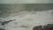 Large storm waves crashing on rocks in slow motion