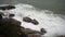 Large storm waves crashing on rocks in slow motion