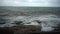 Large storm waves crashing on rocks in slow motion