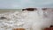 Large storm waves crashing on rocks in slow motion.