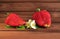 Large strawberry berries with flowers lie on a wooden background