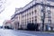 A large street with almost no cars. A large building with many windows.