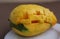 Large sugar tropical mango fruit with no skin ready to eat on white plate look sideways