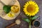 A large sunflower, a bottle of oil, seeds on the table. Top view.