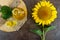 A large sunflower, a bottle of oil on the table. Top view.