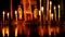 Large table with many burning candles on background of the crucifixion of Jesus Christ