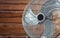 Large tabletop ventilator on the table against the background of a wooden wall. The concept of heat, hot weather, air conditioning