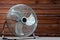 Large tabletop ventilator on the table against the background of a wooden wall. The concept of heat, hot weather, air conditioning