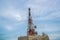 Large telecommunication tower against sky and clouds in background