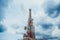 Large telecommunication tower against sky and clouds in background