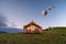 Large tent with tourists camping glowing on hill and balloons flying in the sky at countryside