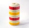 Large thick candle with colored horizontal stripes Isolated on a white background