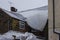 Large thick sheet of icy snow hanging off roof.