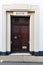 A large traditional double wooden security door with a sign for the bank above