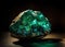 Large translucent natural emerald stone on dark background close up.