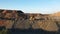 A large truck unloads iron ore in a quarry aerial view.