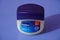 A large tub of Vaseline petroleum jelly isolated blue background. : A jar of Petroleum jelly which is used as over the counter