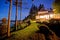 Large two story house with lots of lights in the summer evening.