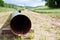 A large unused gas pipe can be seen in the foreground and leads to the blurred background with pipe laying equipment in the pictur