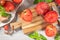 Large variety of tomatoes on rustic kitchen counter. Preparation of tomato sauce with onions and basil