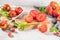 Large variety of tomatoes on rustic kitchen counter. Preparation of tomato sauce with onions and basil