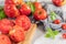 Large variety of tomatoes on rustic kitchen counter. Preparation of tomato sauce with onions and basil