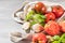 Large variety of tomatoes on rustic kitchen counter. Preparation of tomato sauce with onions and basil