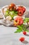 Large variety of tomatoes on rustic kitchen counter. Preparation of tomato sauce with onions and basil