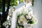 large vase of flowers stands in nature, lush white colors in a white stone vase, a wedding arch decoration, wedding dec