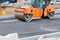 Large vibratory road roller are working on a construction site, compacting fresh asphalt