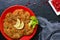 Large Viennese schnitzel on a red plate with lemon on a black background. Meat dish. Top view, flat lay