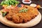 A large Viennese schnitzel and tomato salad