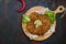 Large Viennese schnitzel on a wooden board with lemon on a dark background. Meat dish.