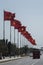 Large Vietnamese and communist flags on a blue sky background follow a road